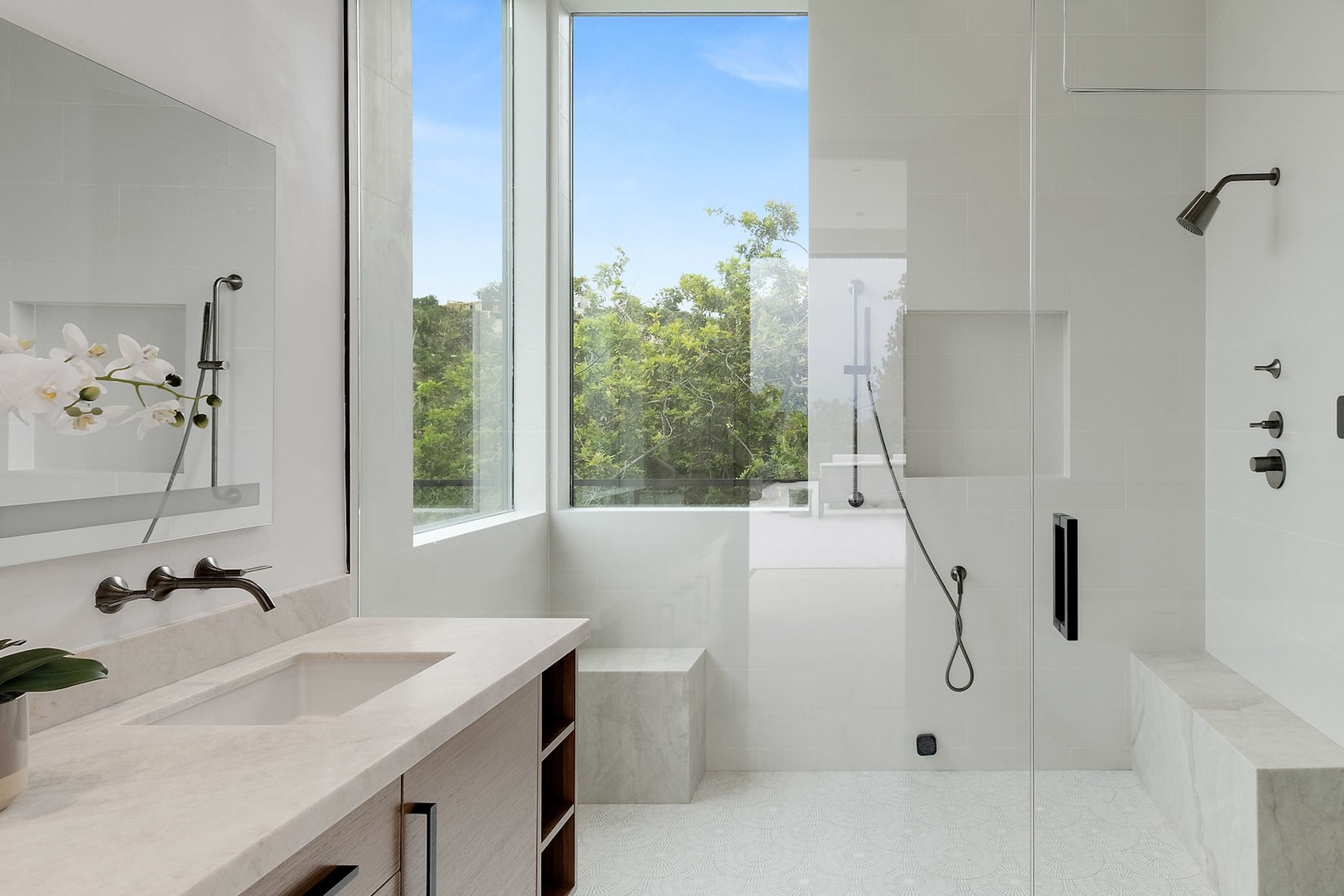 Bathroom remodel San Diego showcasing a luxury modern bathroom with glass shower enclosure, soaking tub, and bright minimalist interior design with large window views.