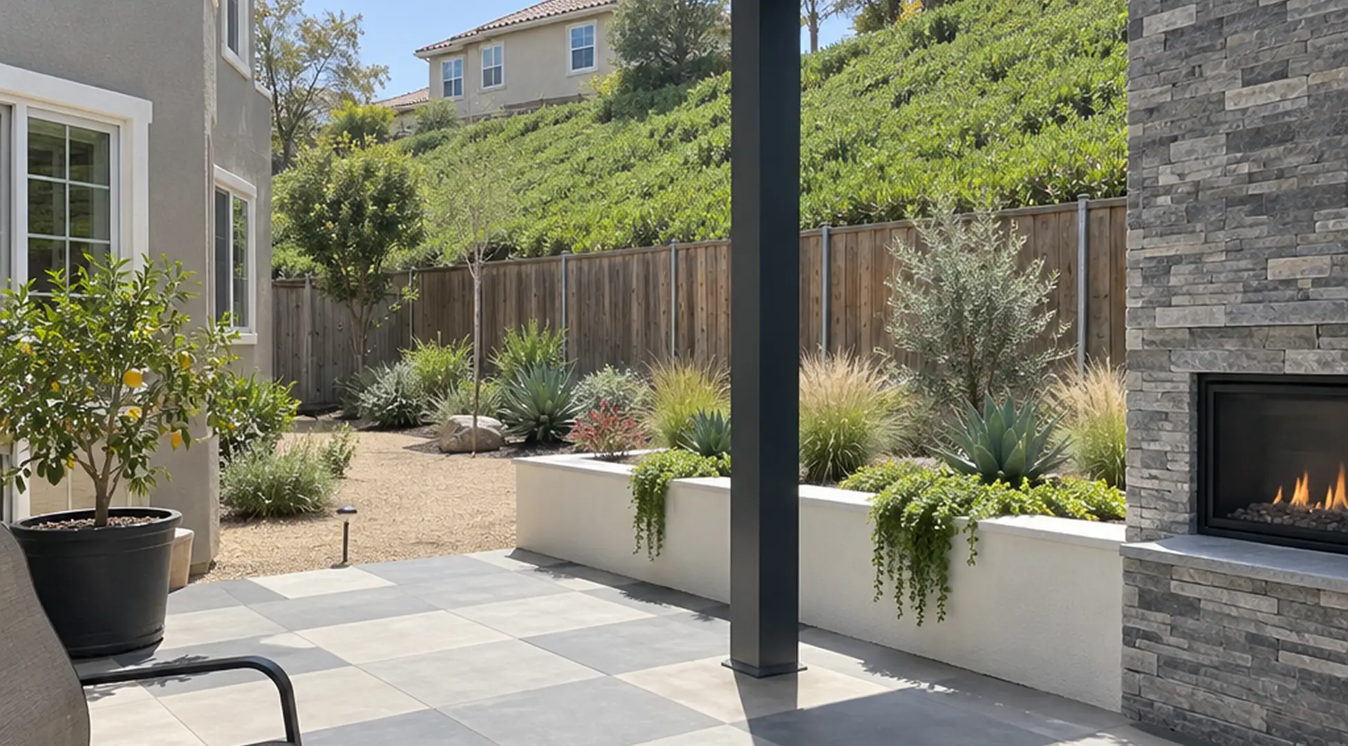 Finished Carmel Valley backyard with a solid-roof patio cover, stone fireplace column and checkerboard tile patio