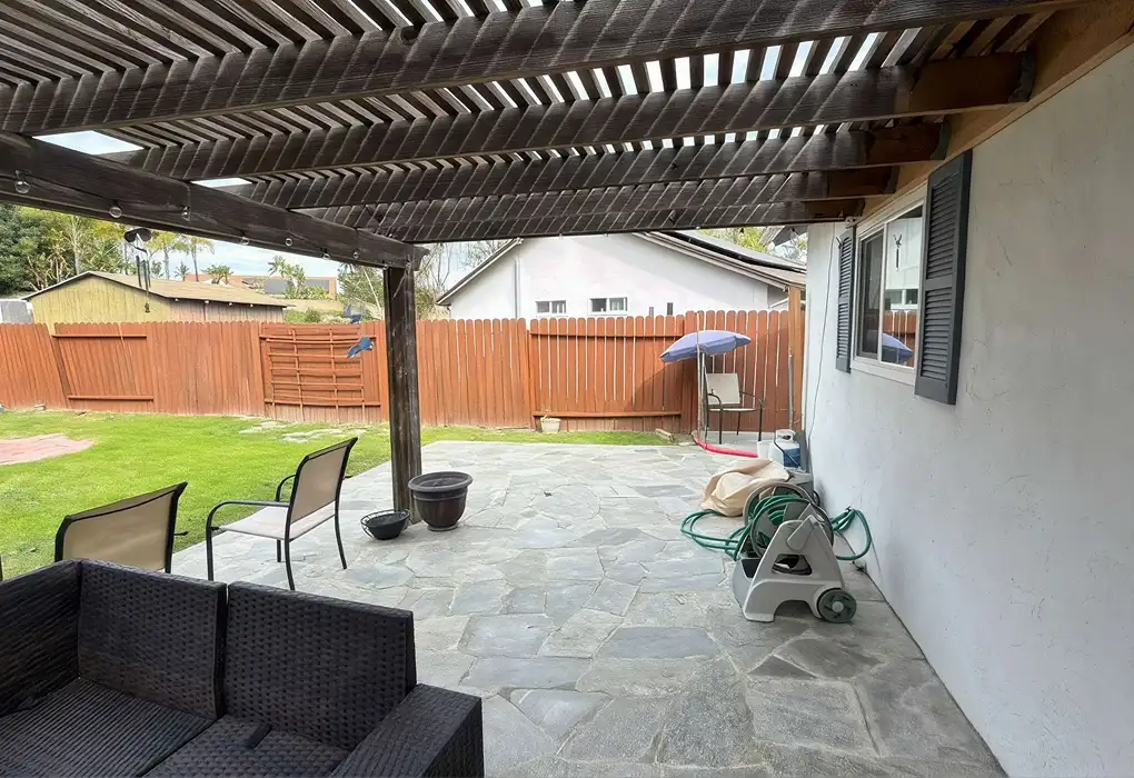 Finished exterior painting of a stucco wall with shutters, pergola, and patio on a San Diego home by Shiro Builders Group
