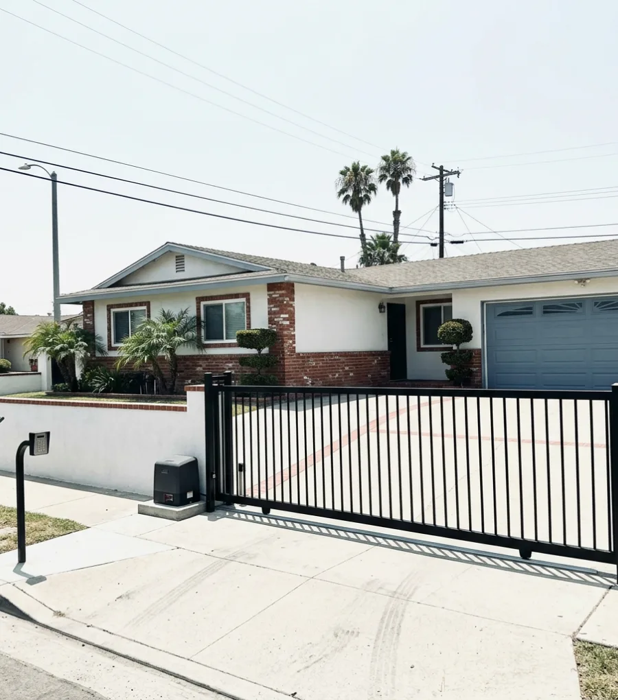 Automatic sliding steel driveway gate with keypad post at a San Diego home